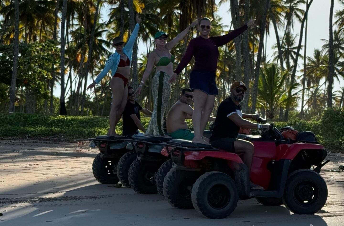 Clientes da Bella Bahia no passeio de quadriciclo numa praia de coqueiros